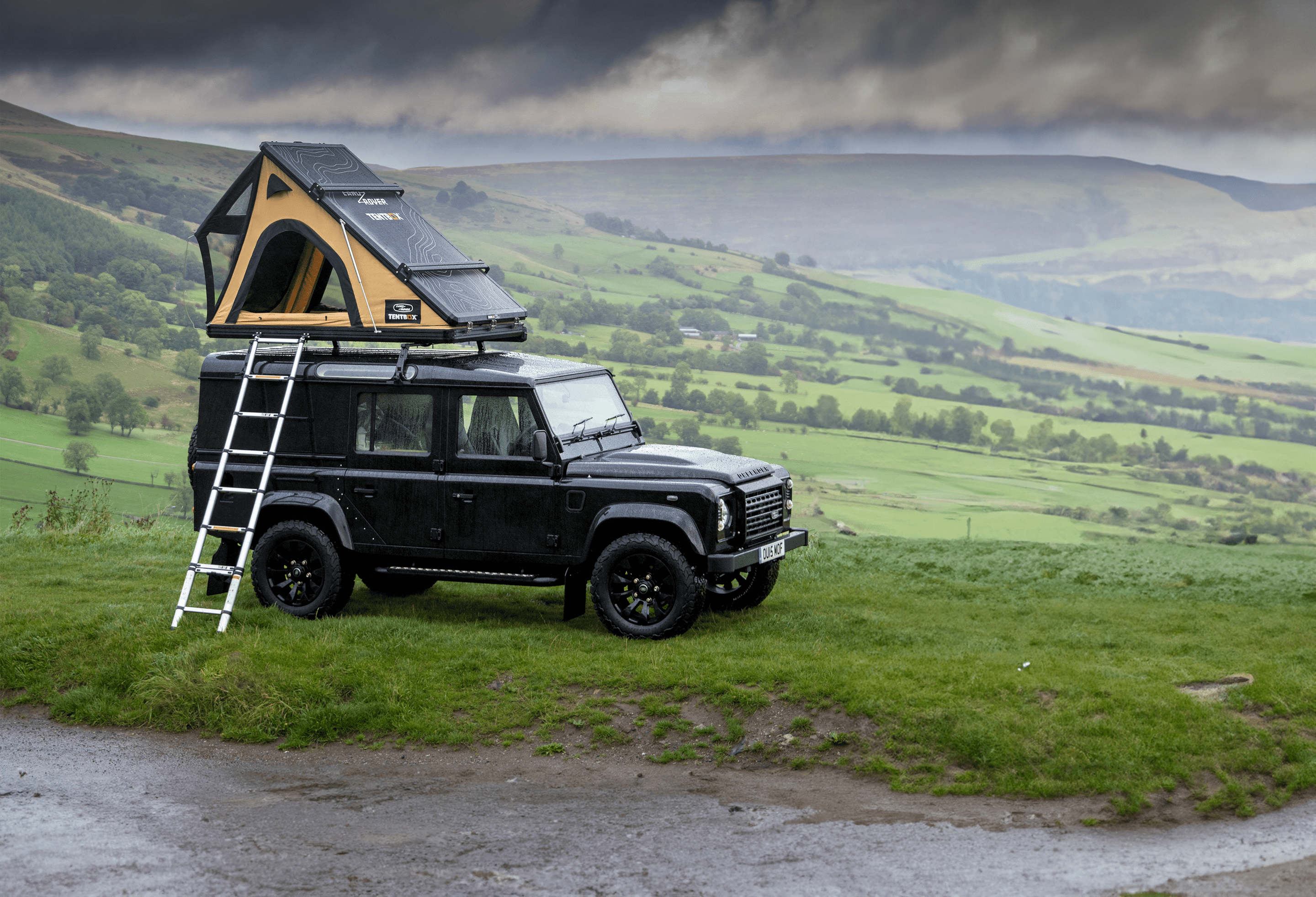 Islay Defender parked on a rocky shore.