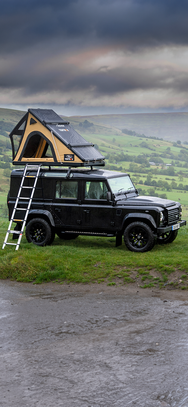 Islay Defender parked on a rocky shore.